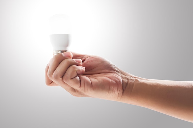 Light bulb on human hand with gray background