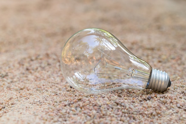 The light bulb is empty on the sand. Energy concept