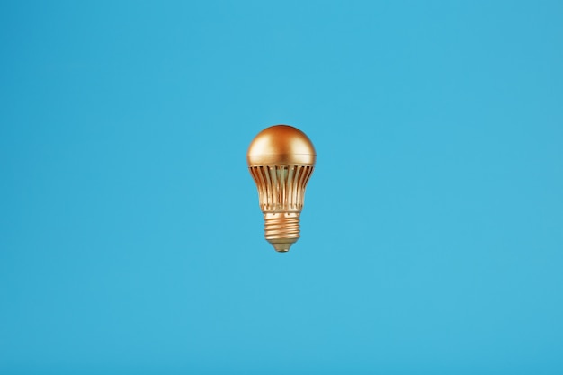 The light bulb is gold on a blue wall.