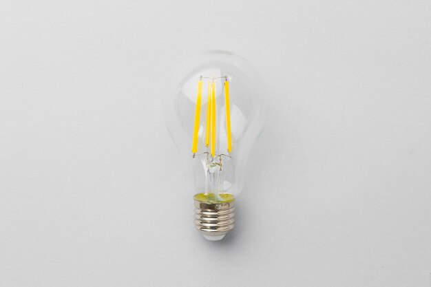 Light bulb on light grey paper surface