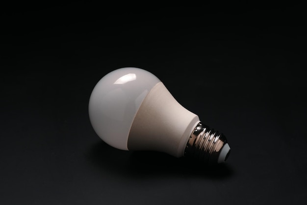 A light bulb that is turned off on a black background