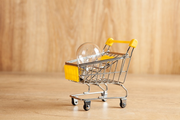 Light bulb in a trolley on a wooden background