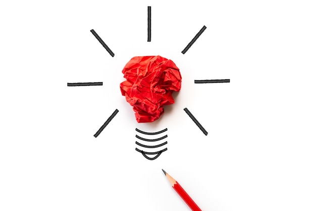 Light bulb with crumpled colorful paper and red pencil on white background.