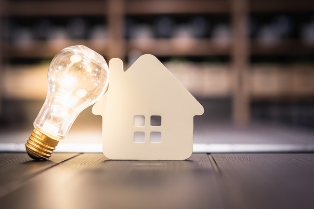 Photo light bulb with wood house on the table,