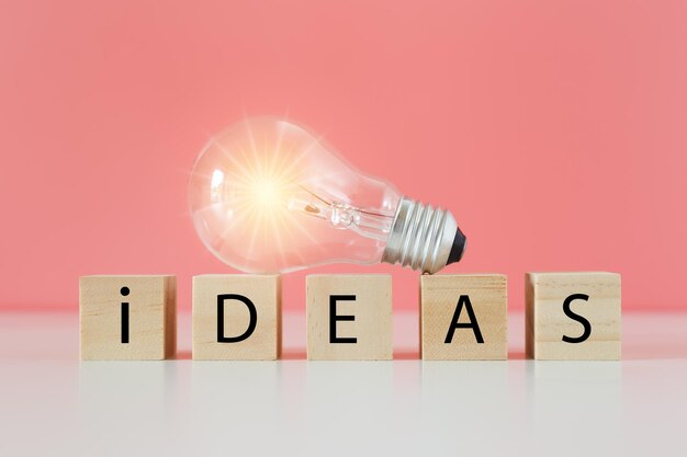light bulb on wooden cube blocks with word ideas thinking creative genius innovation knowledge successful symbol thinking creative concept
