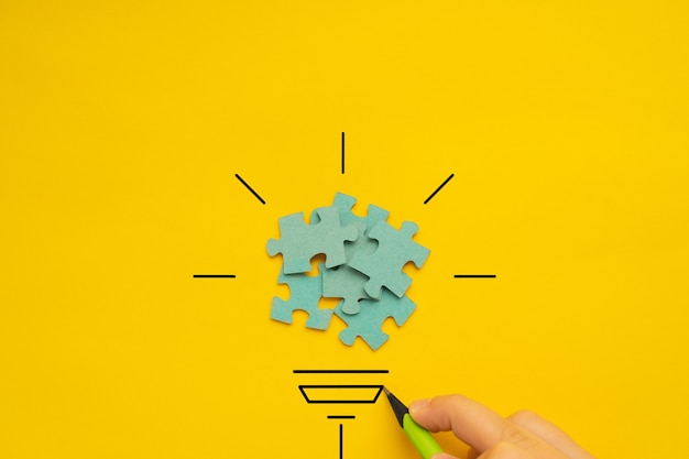 ビジョンとアイデアの概念的なイメージの黄色の背景の上の電球
