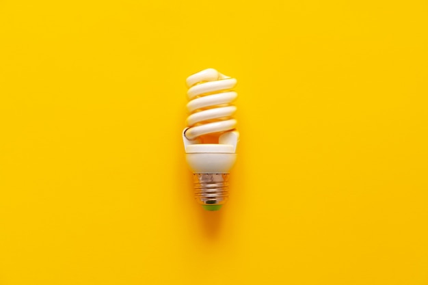 Light bulb on yellow paper top view