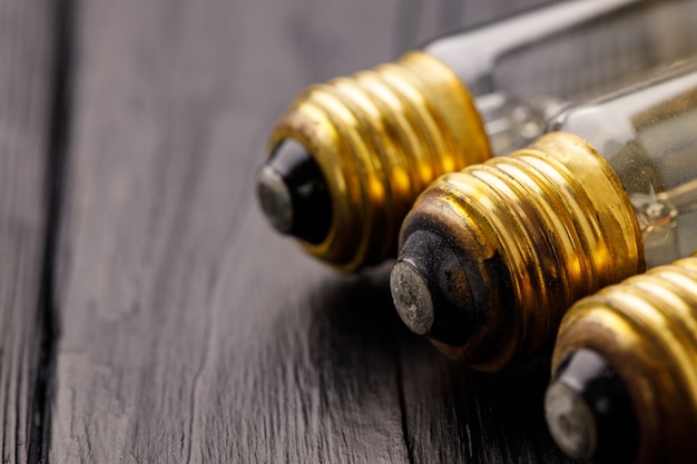 Light bulbs on dark wooden surface close up