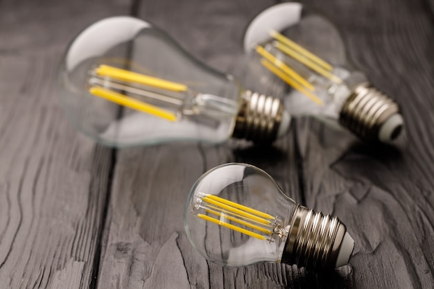 Light bulbs on dark wooden surface close up