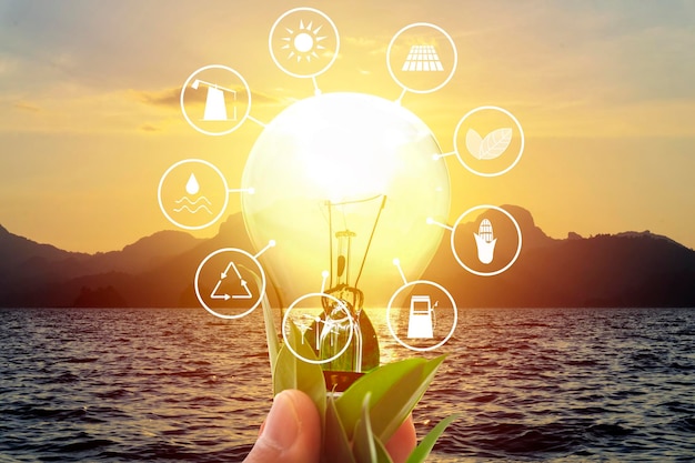 電球のエネルギー資源アースデイアイコン省エネコンセプト世界の再生可能エネルギー源山と海太陽はエネルギー源です