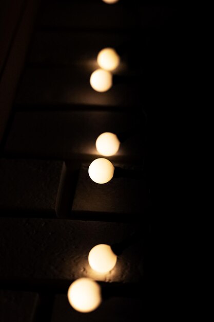 Light bulbs garlands on brick wall closeup