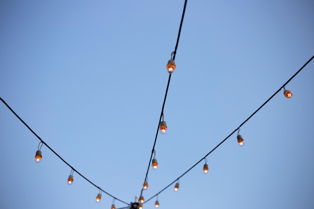 Light bulbs on string wire with sky