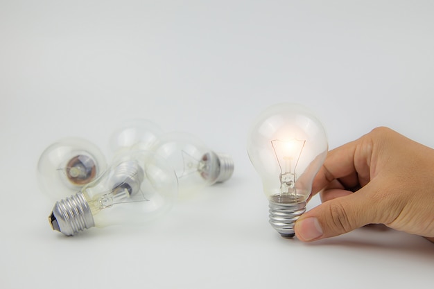 創造性の概念を手に明るい光と電球。