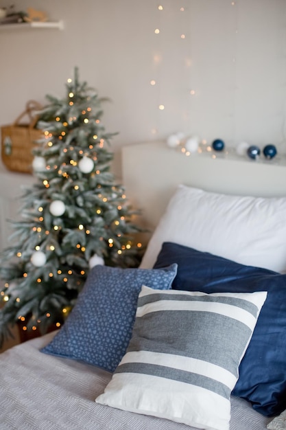 Light Christmas bedroom with Christmas tree Christmas lights pillows and other festive decorations