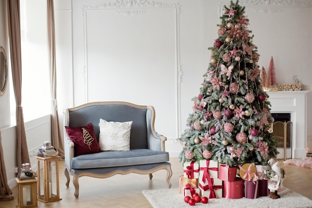 사진 회색 소파와 크리스마스 트리가 있는 밝은 크리스마스 인테리어 크리스마스 장식이 있는 아늑한 방