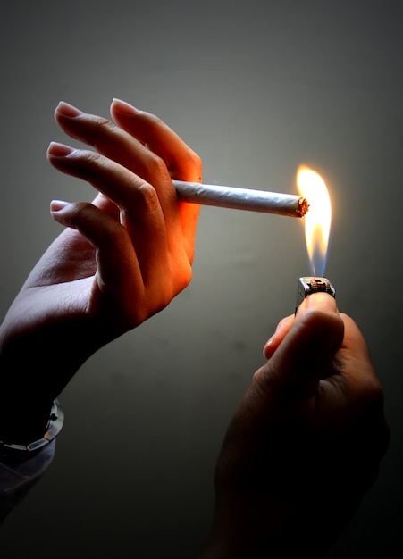 light a cigarette with a match. smoking can be detrimental to health.