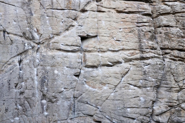 Light coarse natural rock stone background Mining cliff rough front surface Big limestone stack backdrop Heavy grunge damaged granite block texture