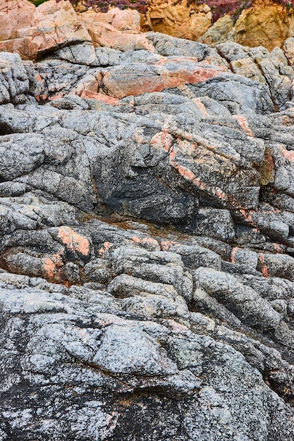 明るく濃い灰色の石の崖の壁とタンの岩と石の背景資産の裂け目