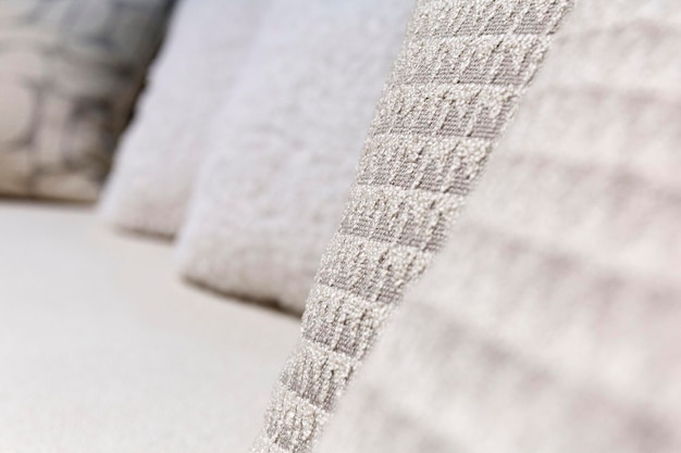 Light decorative pillows made of fabric on the sofa Design in the interior Closeup Selective focus