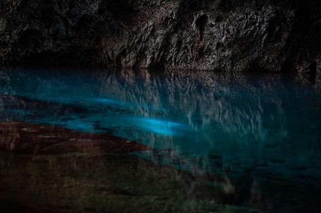 light descends into the darkness of a submerged cavern with blue lake concept of travel