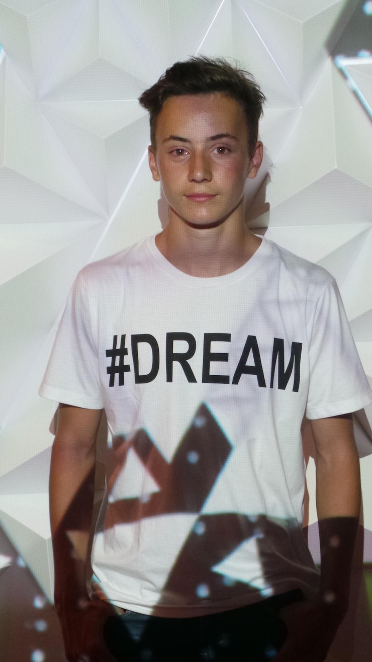 Photo 夢のテキストのtシャツを着たティーンエイジャーの少年に光が落ちる
