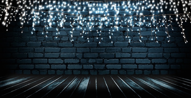 Photo light garland on a dark brick wall reflection of lights on the asphalt neon light smoke smog