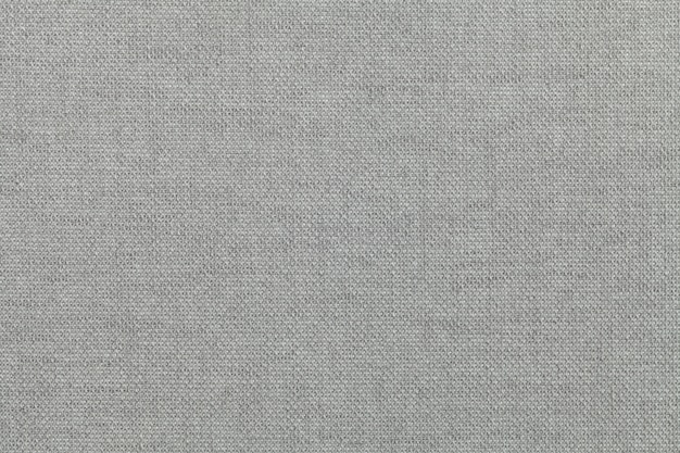 Светло-серый, фон из текстильного материала. Ткань с натуральной текстурой. Фон.