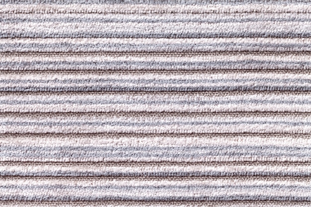Sfondo grigio chiaro di una materia tessile a maglia. tessuto con un primo piano a strisce di struttura.
