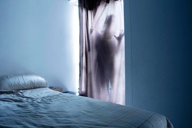 Light gray and blue room and ghost behind the curtains