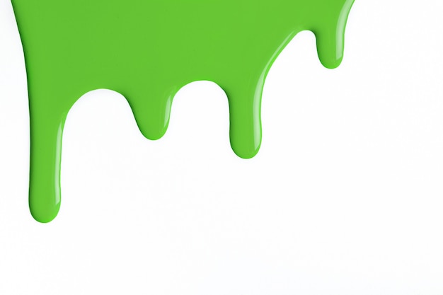 Light green liquid drops of paint color flow down on isolated white background