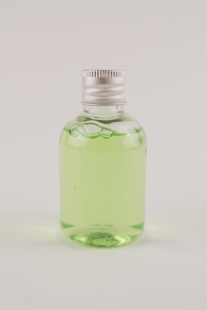 Light green shampoo in a transparent bottle on a white background