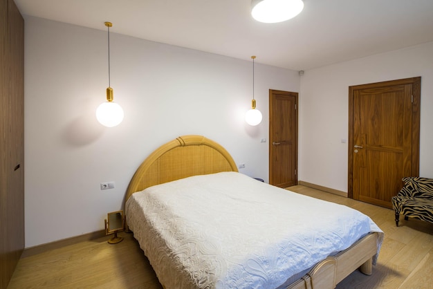 Foto interno chiaro della camera da letto mobili in legno porte chiuse letto rifatto con rivestimento bianco casa privata