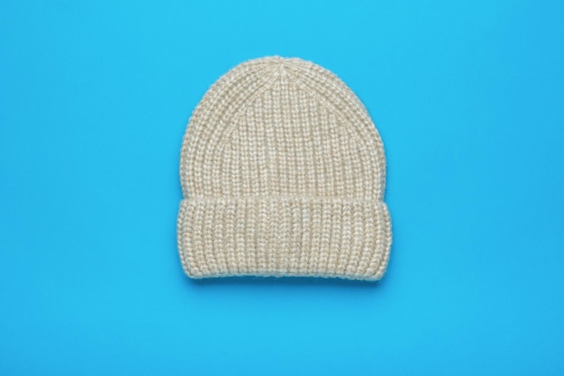 Light knitted hat on a blue background