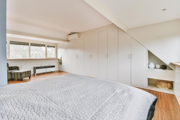 Light mansard bedroom with window and big wardrobe