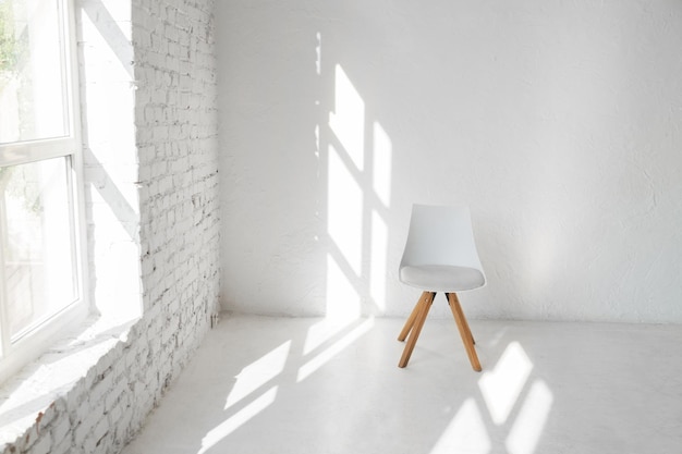 Светлый минимализм современный скандинавский интерьер студии лофта с креслом для кафе на белой стене возле окна. Смоделируйте тени после полудня, скопируйте космический фон.