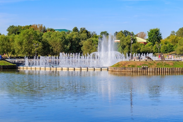 Light and music fountain on the Horseshoe island in Tsaritsyno park in Moscow against Middle Tsaritsynsky pond at sunny summer morning