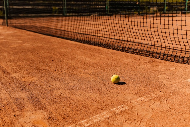 밝은 주황색의 비어 있는 야외 점토 코트 표면은 테니스를 치기 위한 마른 그라운드 베이스라인 세부 정보입니다.