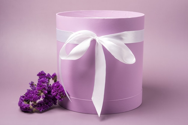 Light pink hat box with purple flowers on light pink background