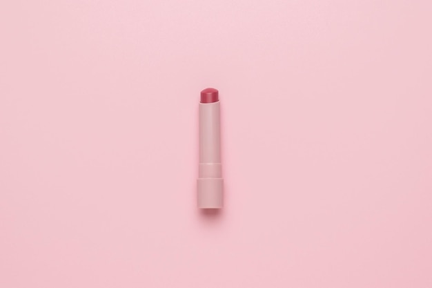 밝은 분홍색 배경에 밝은 분홍색 립스틱 최소한의 화장품 개념 플랫 레이