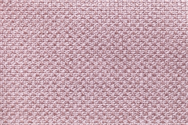 Light pink textile background with checkered pattern, closeup. Structure of the fabric macro.