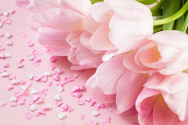 Light pink tulips on a pink background.