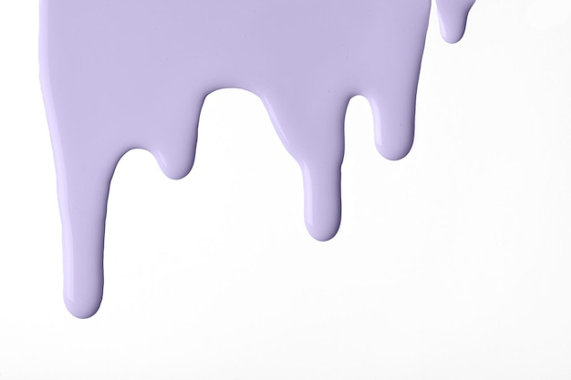 Light purple liquid drops of paint color flow down on isolated white background Abstract violet backdrop