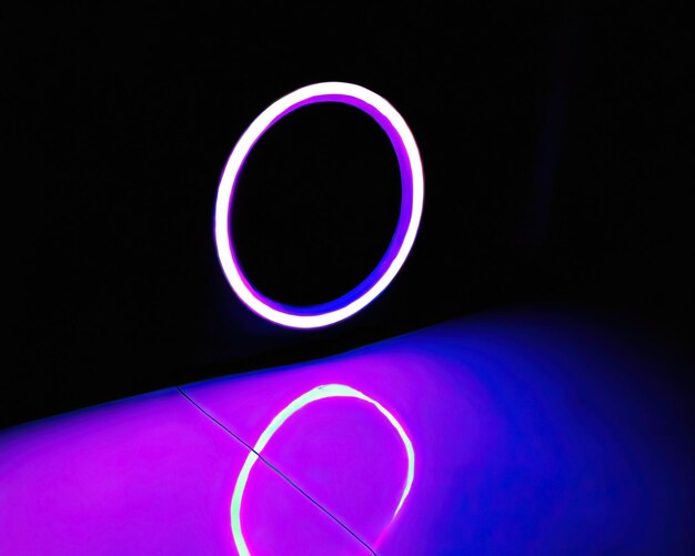 Light rings pink and blue magenta and turquoise with reflections on the floor black background moving light rings