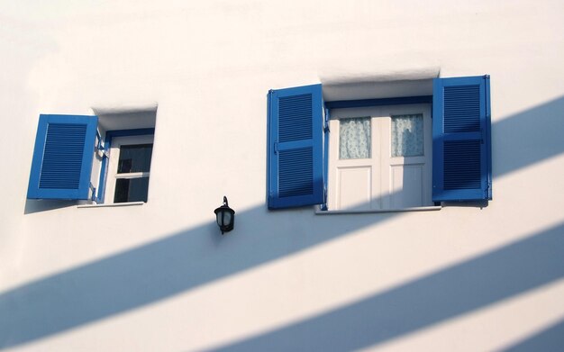 Light and shadow across on the blue window and the white wall