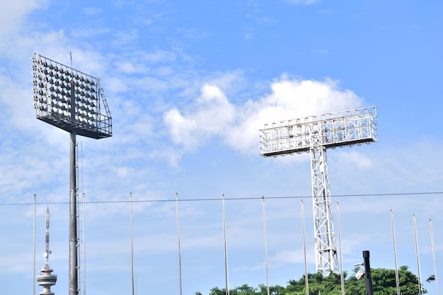 青い空の背景にあるスタジアムのライトタワー