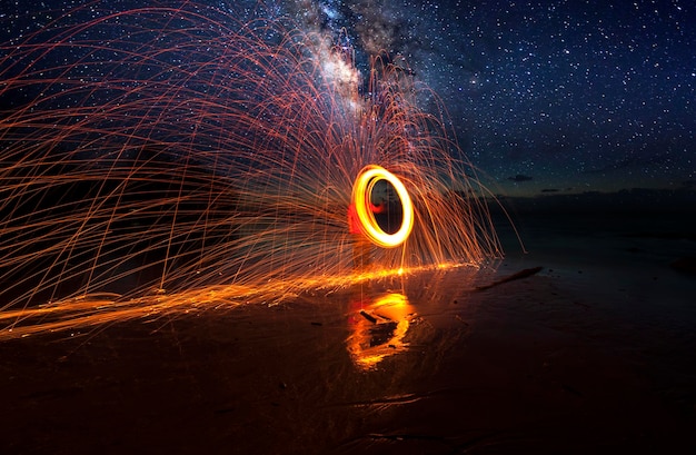 Photo light trails on beach against sky at night