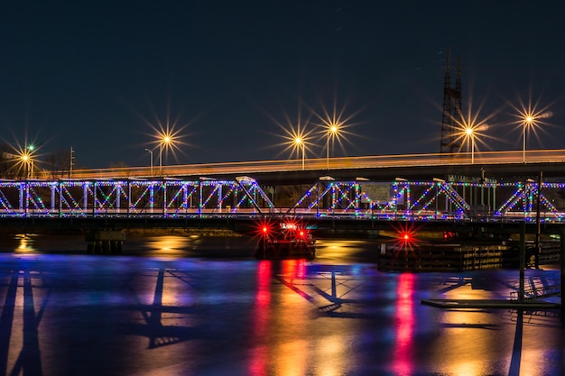 light trails on bridge against sky at night