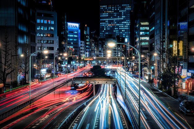 Photo light trails on city street amidst buildings at night