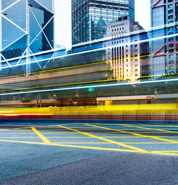 Light trails on city street by modern buildings