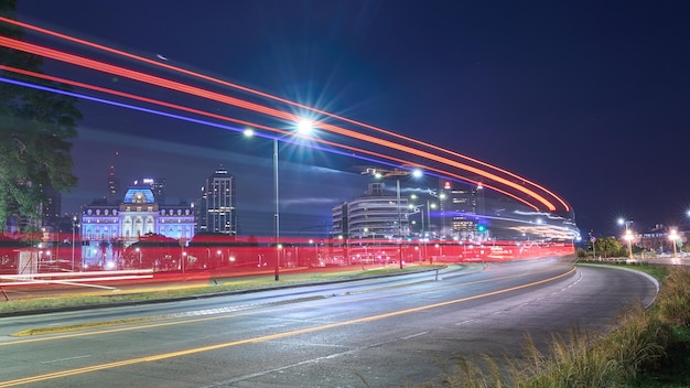 Light trails in a curve with a city in the background